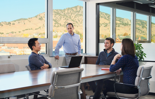 Rubicon team members around a conference table with a view of mountains out the window